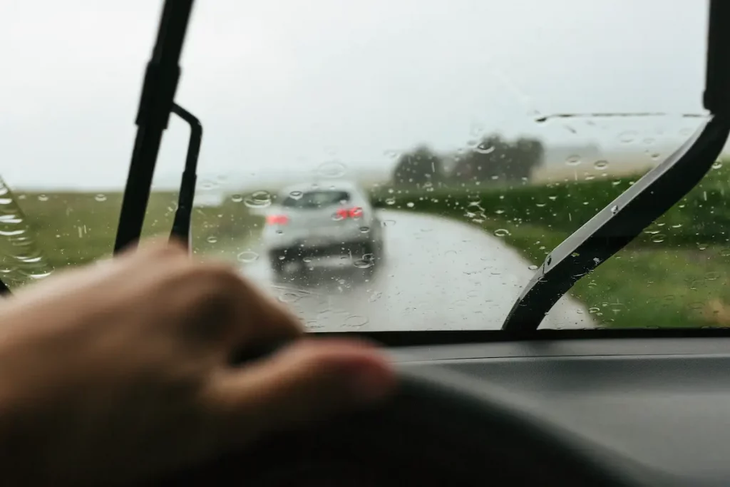 hombre conduciendo bajo lluvia con limpiaparabrisas conducir con lluvia intensa
